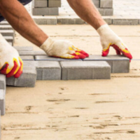 professionals with gloves laying pavers
